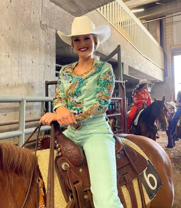 women in turquoise outfit on horse
