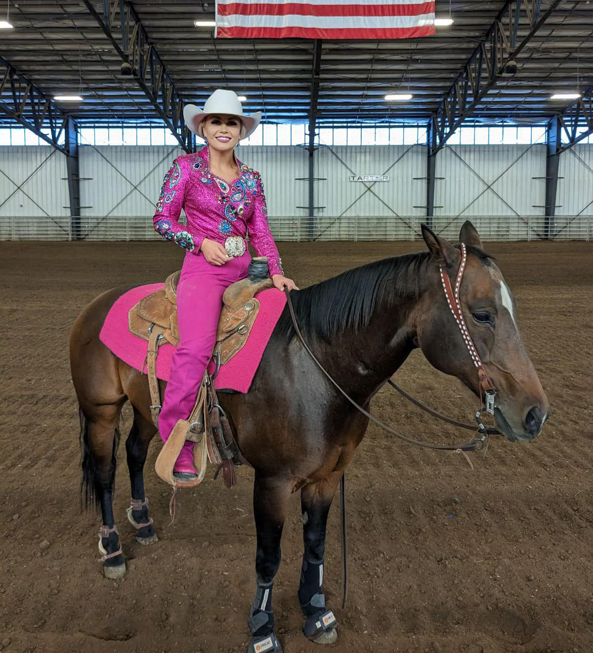 women in bright pink outfit on horse